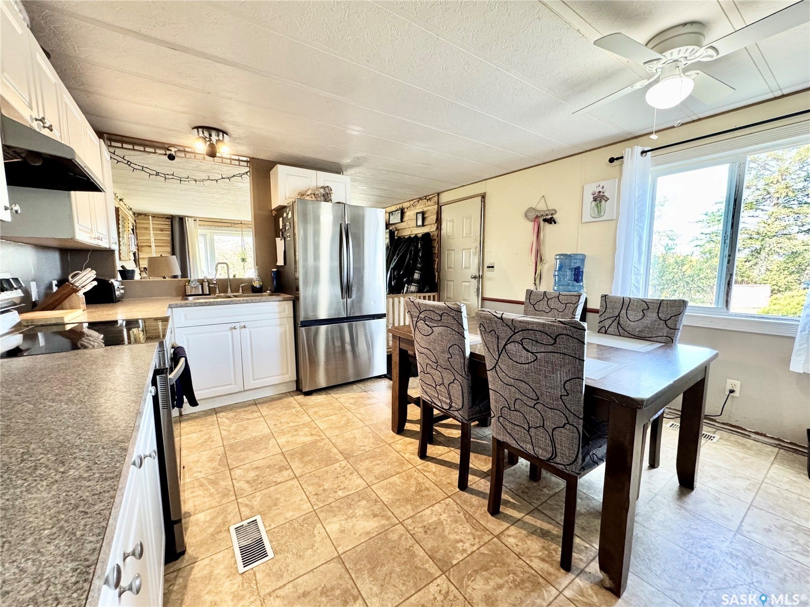 Kitchen featuring stainless steel appliances, white cabinetry, and durable tile flooring