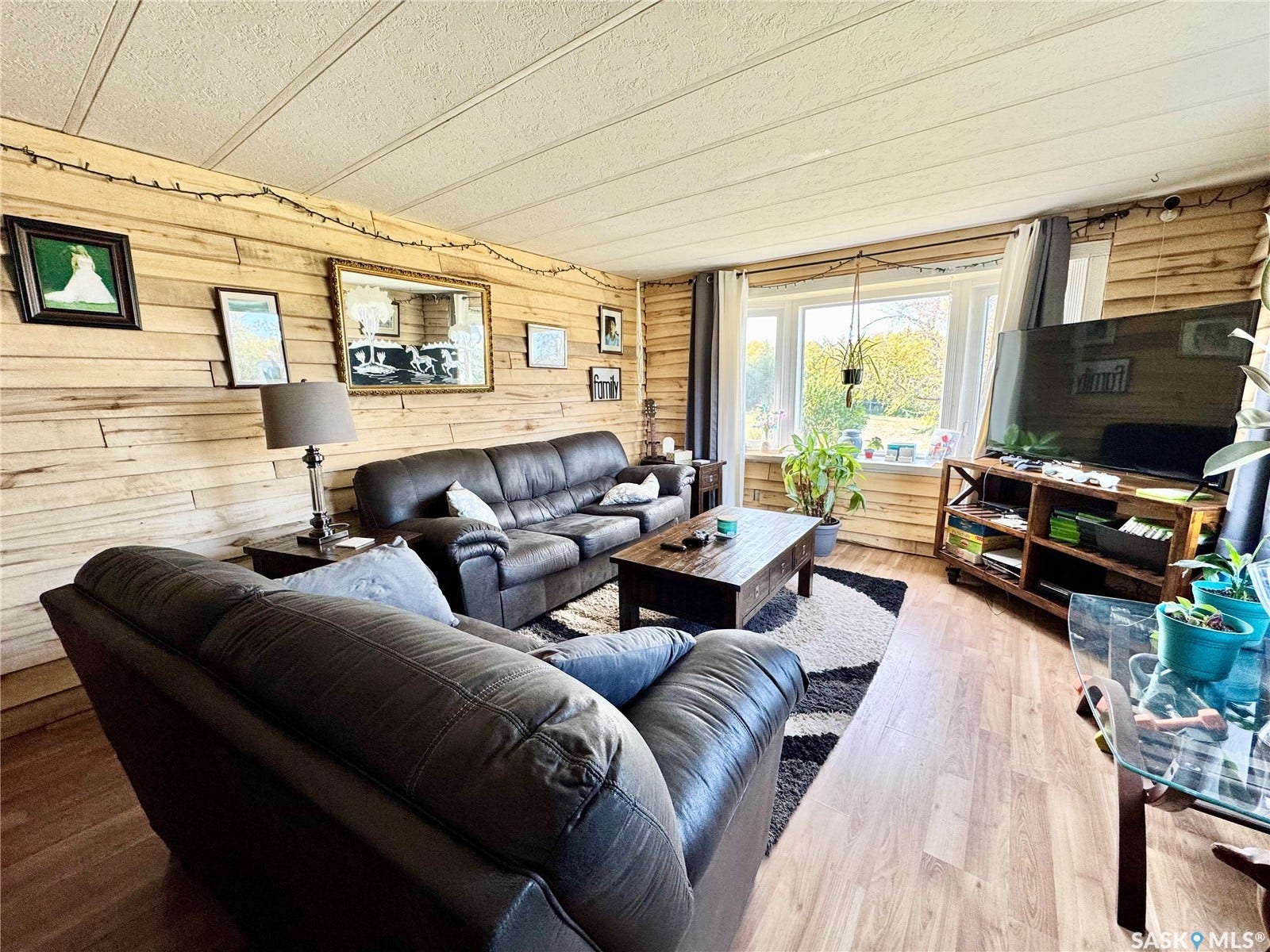 Wood-finish flooring, wood plank walls, and a large window