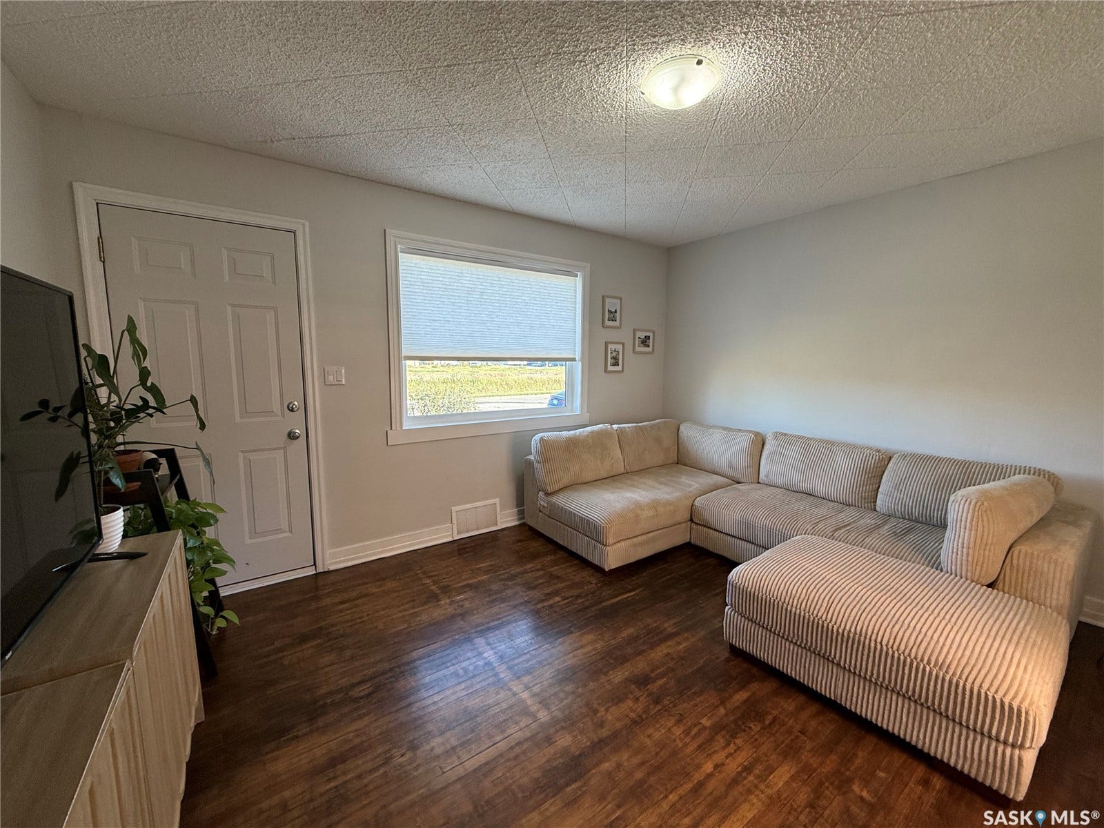 Hardwood-finish flooring, neutral wall tones, white trim, recessed window, and overhead lighting