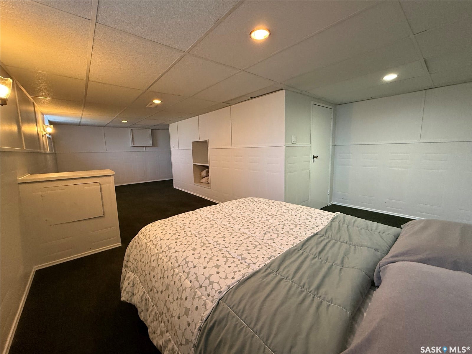 Recessed lighting, surface-mounted lighting fixtures, built-in cabinetry, dark-toned carpeting, and a drop ceiling