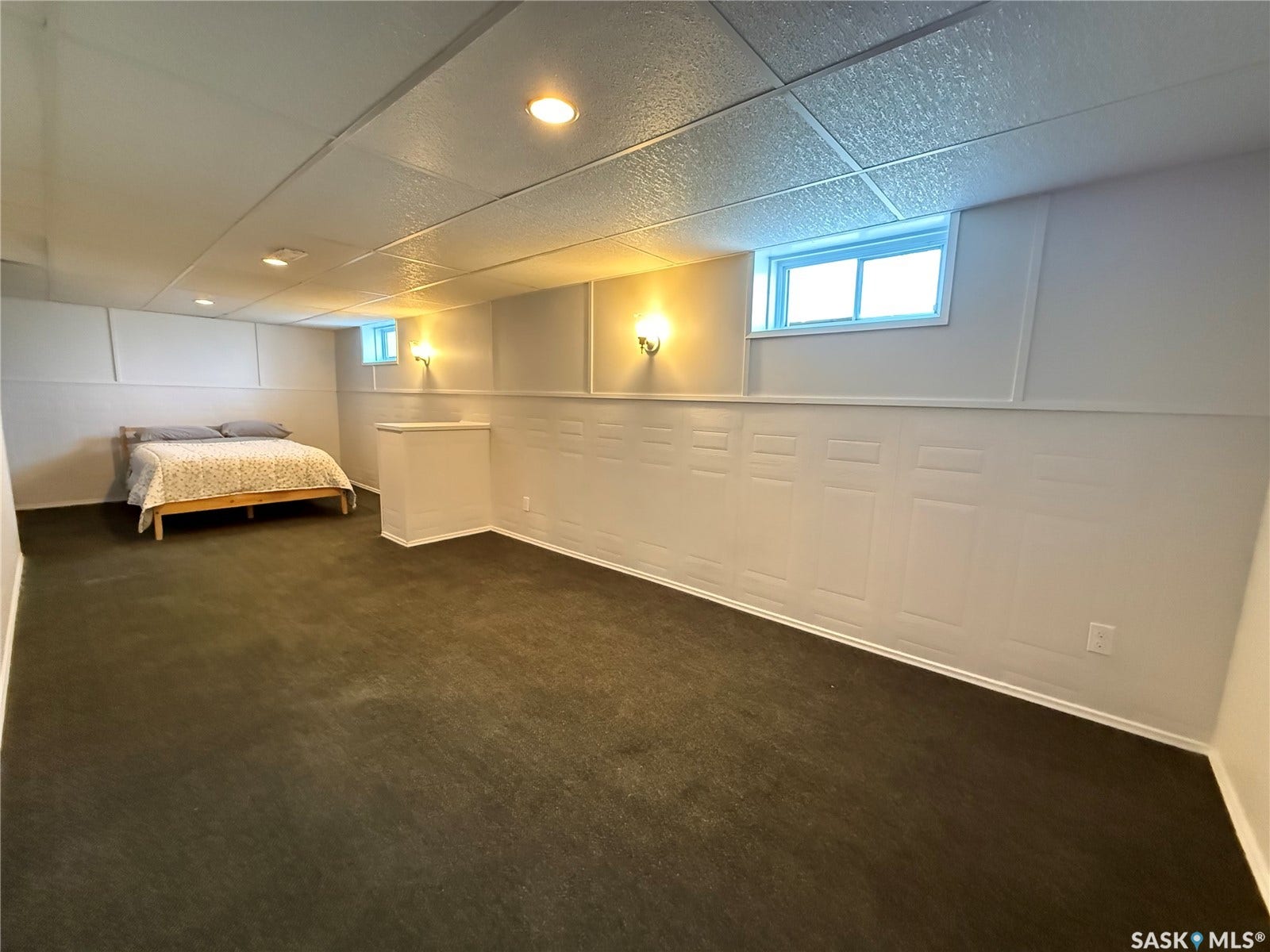 Recessed lighting, wall sconces, drop ceiling, wainscoting, and carpet flooring
