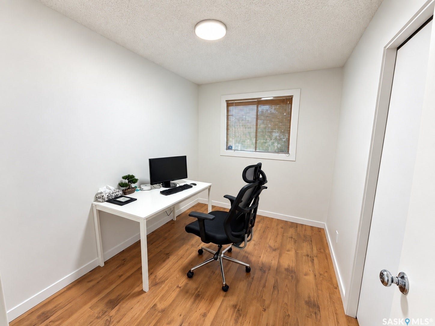 Wood-finish flooring, white walls, and a window with natural light