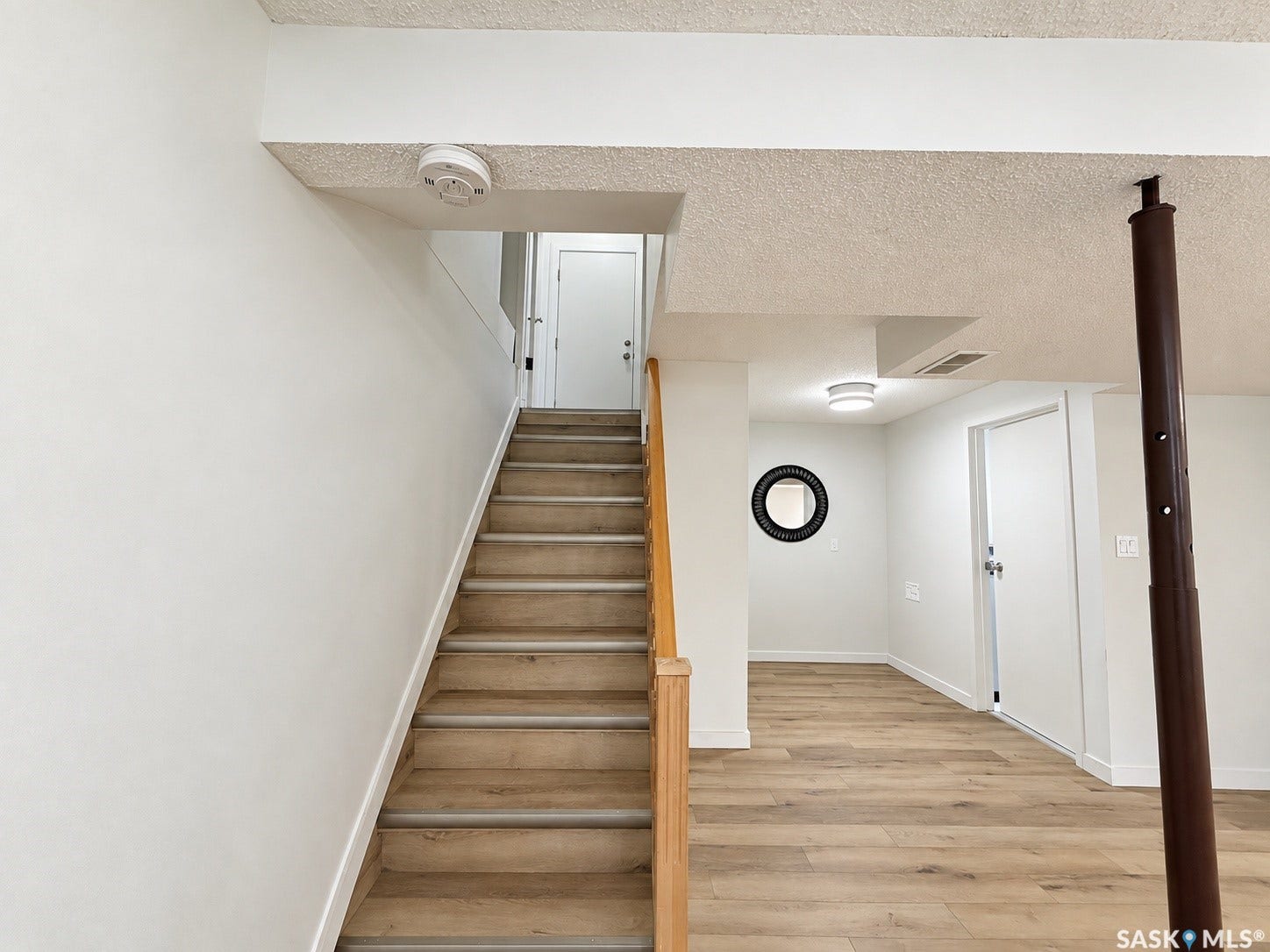 Staircase with wood-finish treads and a light wood handrail