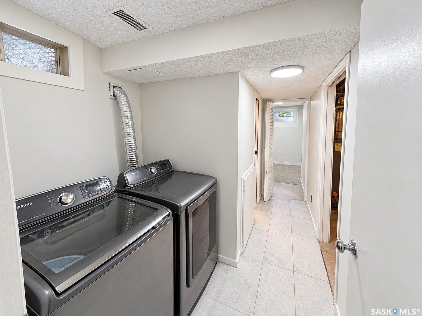 Laundry area featuring a side-by-side washer and dryer, tile flooring, and a round ceiling light fixture