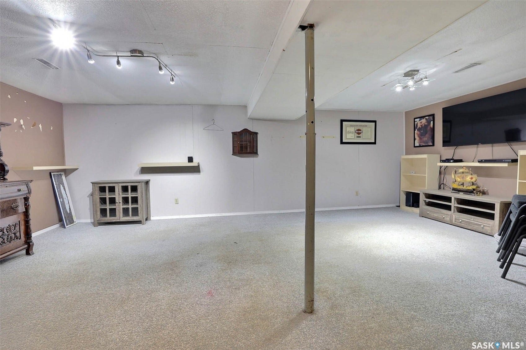 Carpeted flooring throughout, recessed lighting, track lighting, and a neutral color palette
