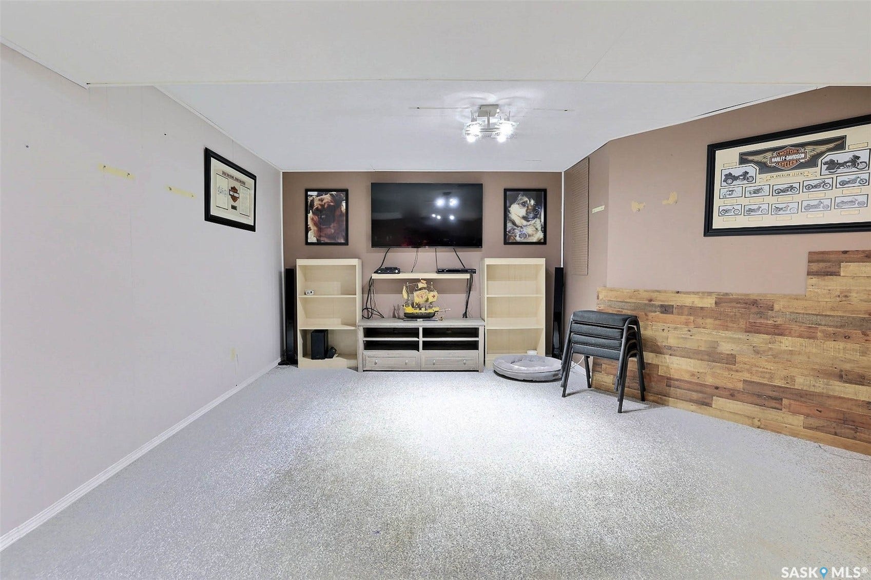Wall-mounted media console, built-in shelving, wood-finish accent wall, and recessed lighting