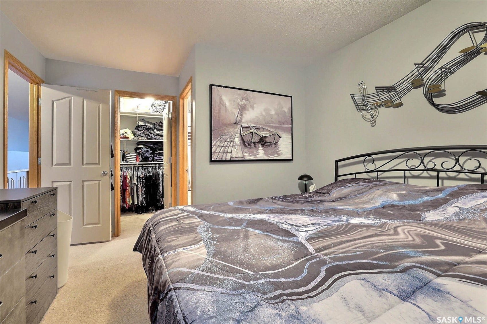 Carpeted flooring with light-toned walls, a paneled door, and a built-in closet with shelving