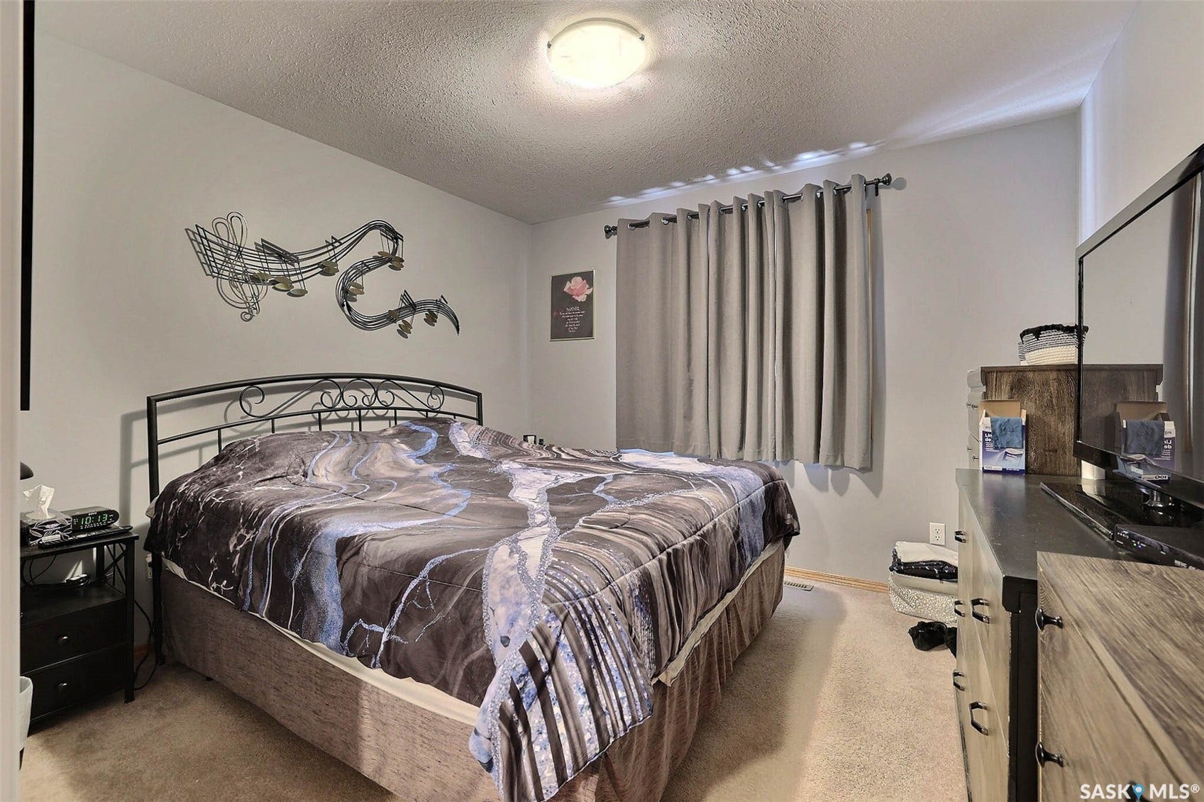Carpeted flooring, window with drapes, and a flush-mount ceiling light