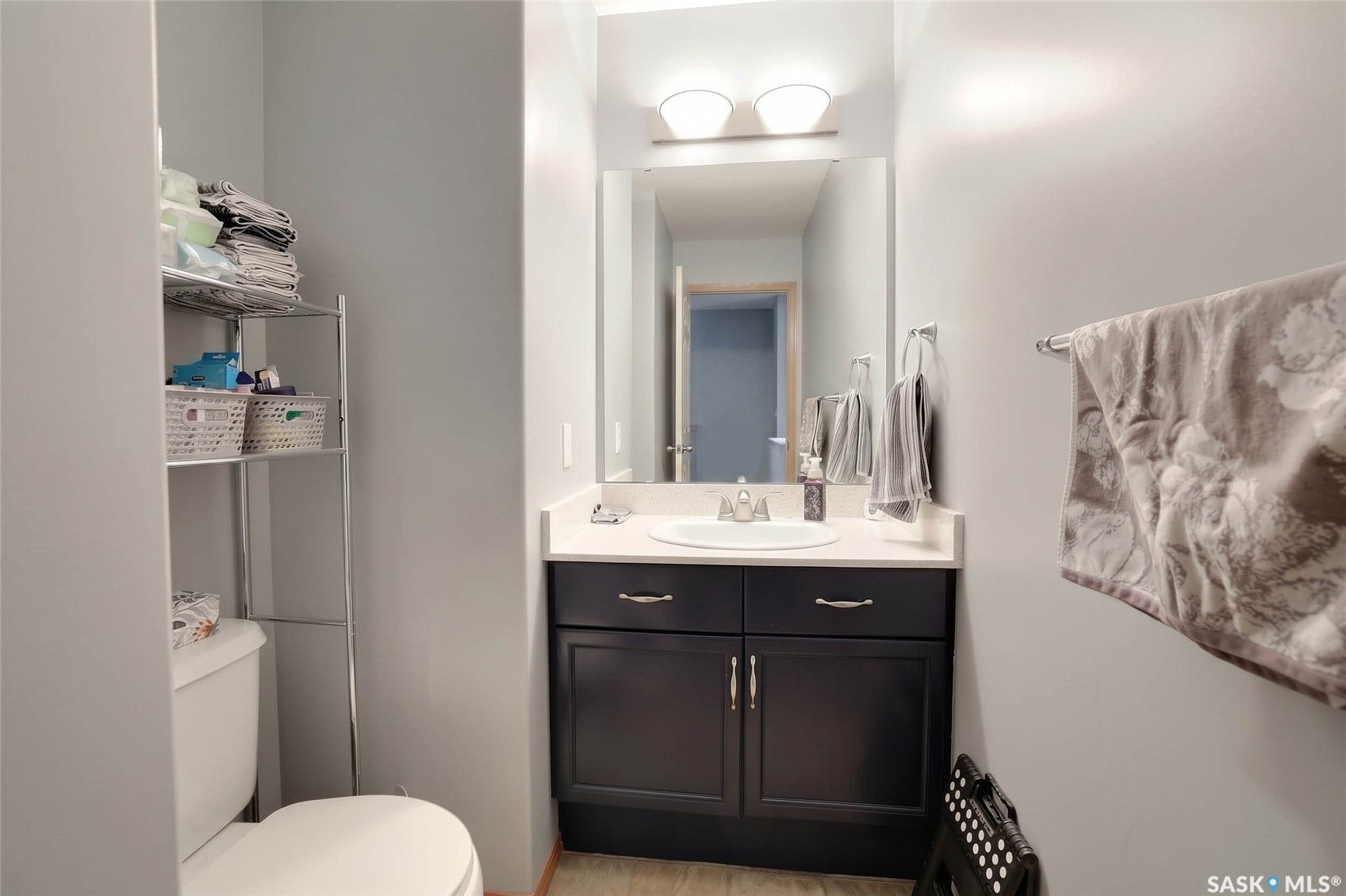 Dark wood-finish vanity with a white countertop and integrated sink