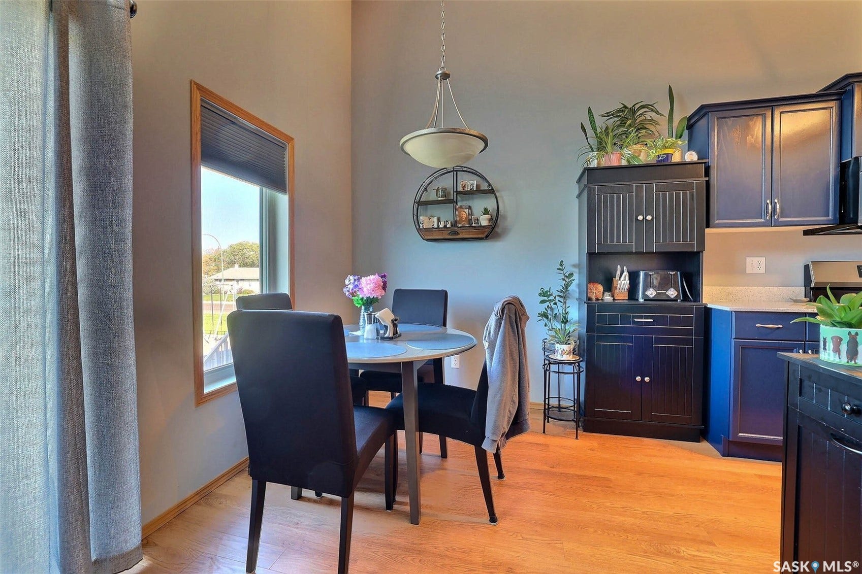 Wood-finish flooring, recessed lighting, built-in cabinetry, modern pendant light fixture, and window with wood trim