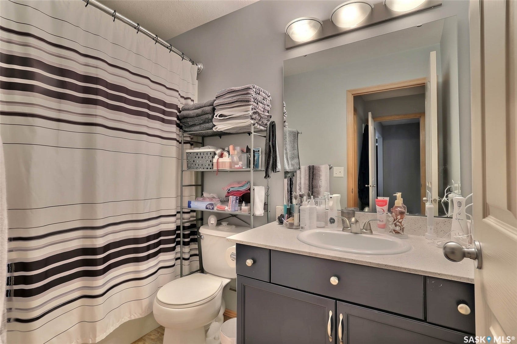 Vanity with integrated sink, dark wood-finish cabinetry, and light-toned countertop