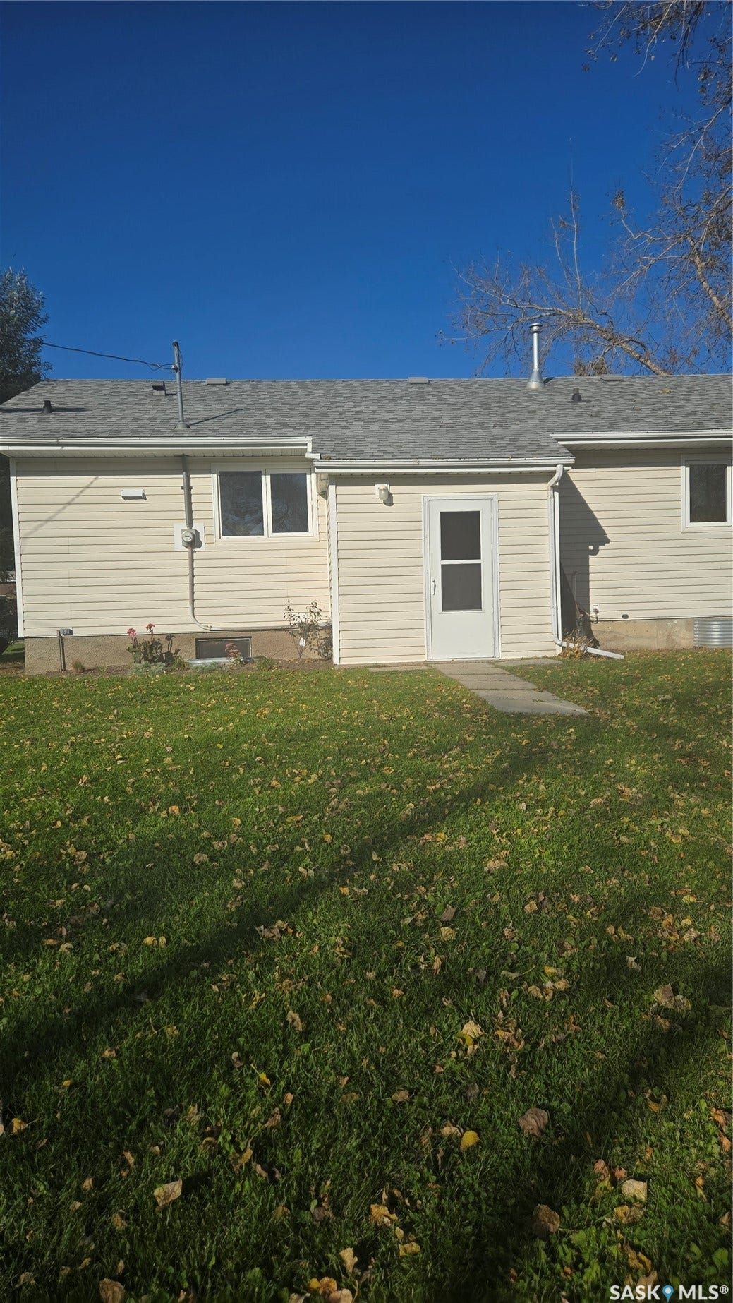 Rear exterior with siding, a white screen door, and a shingle roof