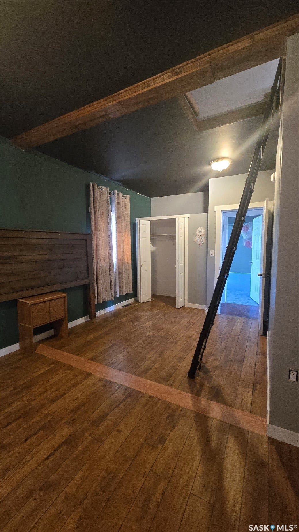 Wood-finish flooring throughout, featuring a recessed ceiling light fixture, and two built-in storage closets
