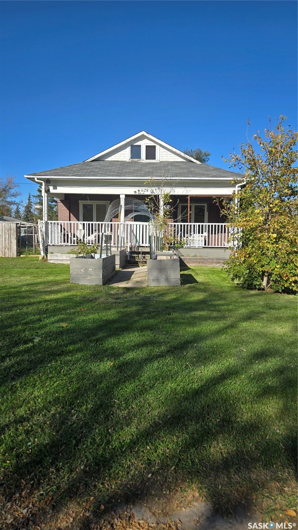 Covered front porch with white railings, a pitched roofline, and a dormer window