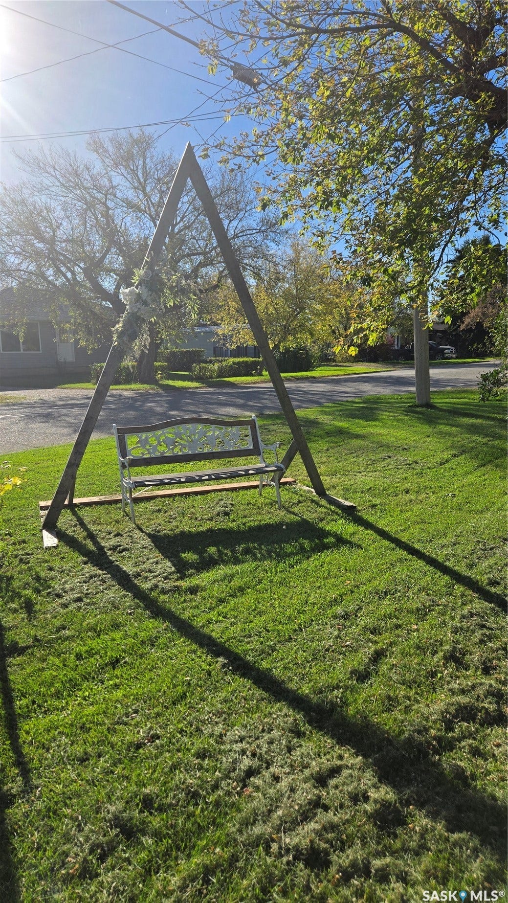 Manicured lawn with mature trees and a decorative swing