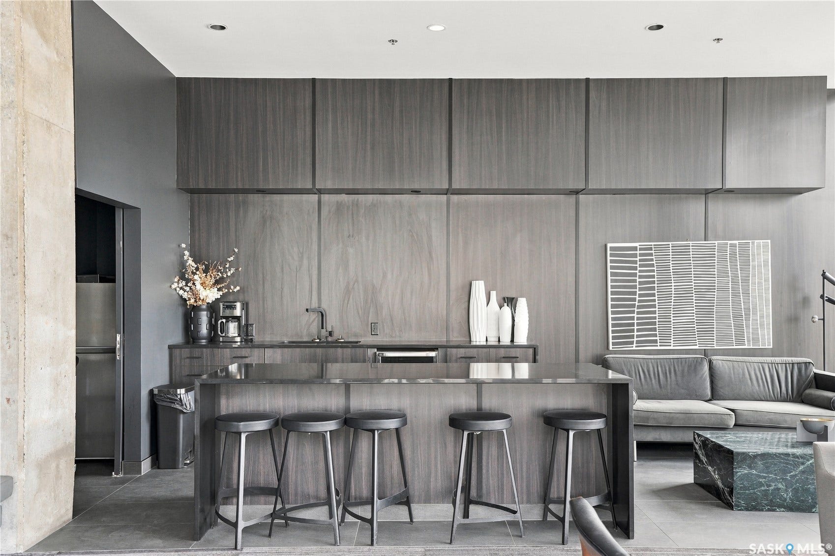 Kitchenette featuring wood-finish cabinetry, built-in sink, and integrated counter seating