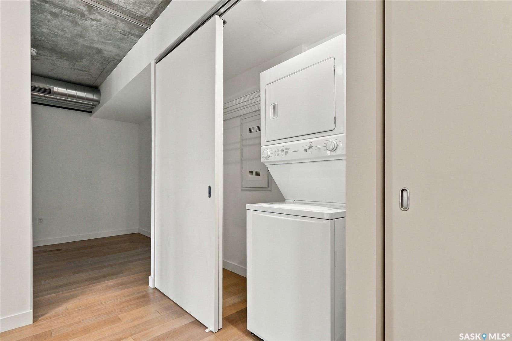 White stackable washer and dryer within a dedicated utility closet