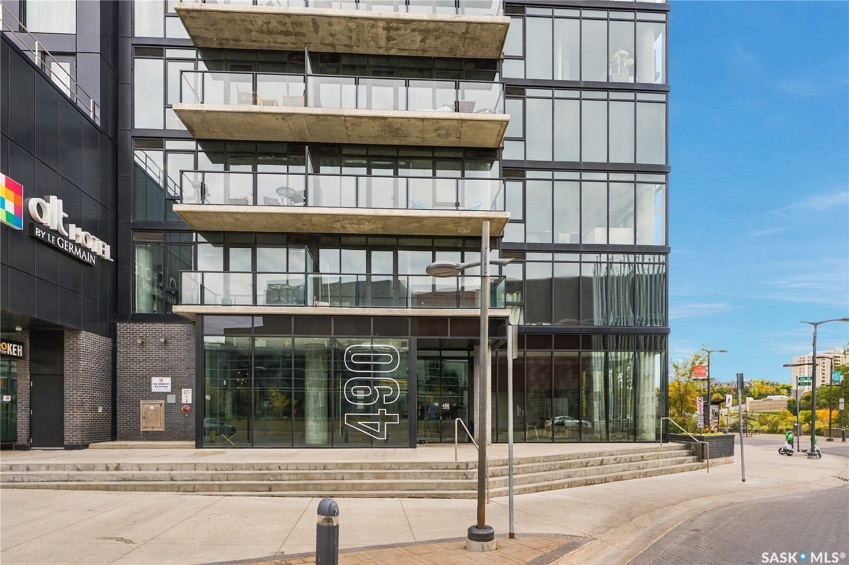 Modern high-rise exterior with expansive window walls and concrete balconies featuring glass railings