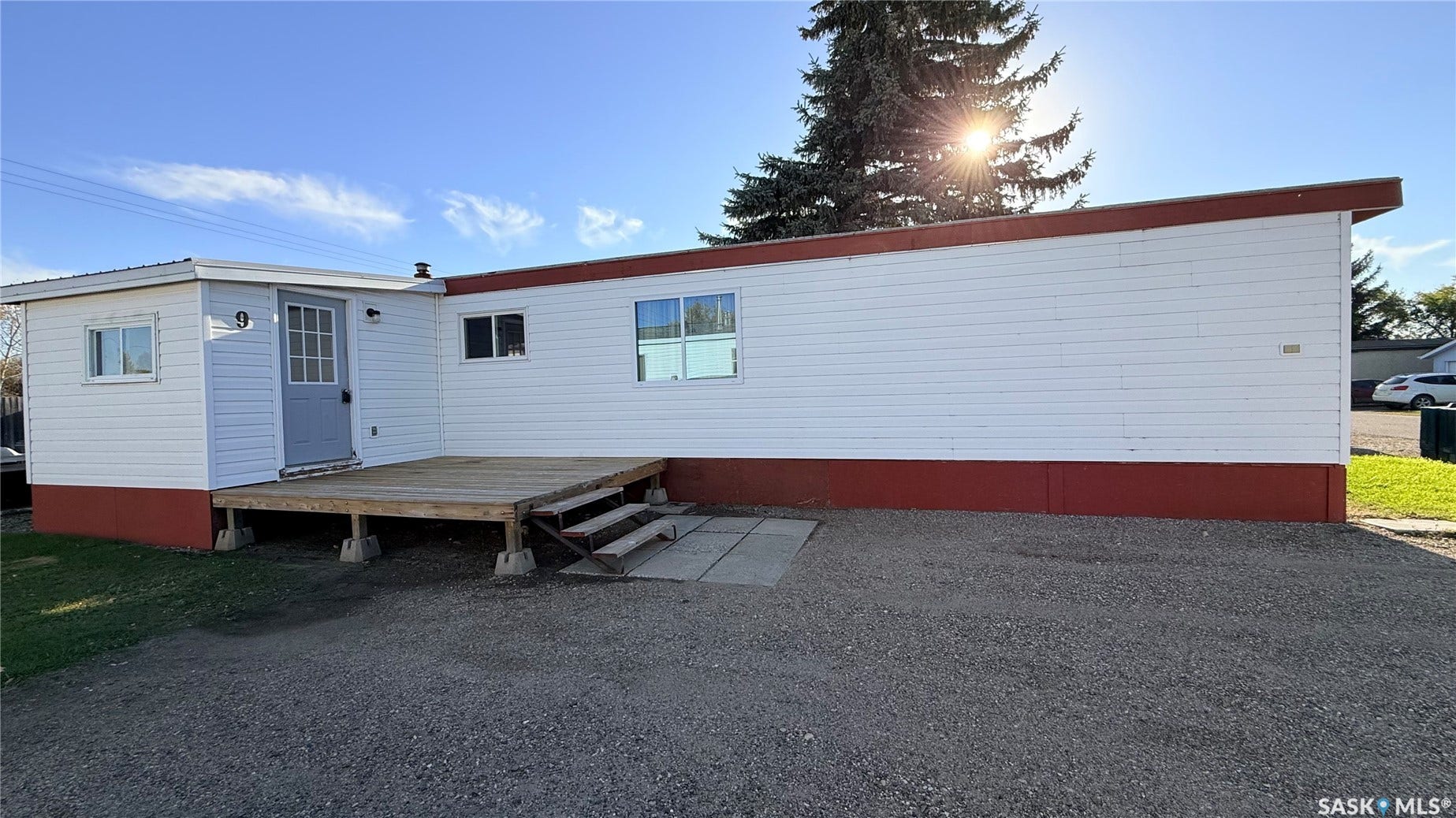 White horizontal siding exterior with a red foundation and trim