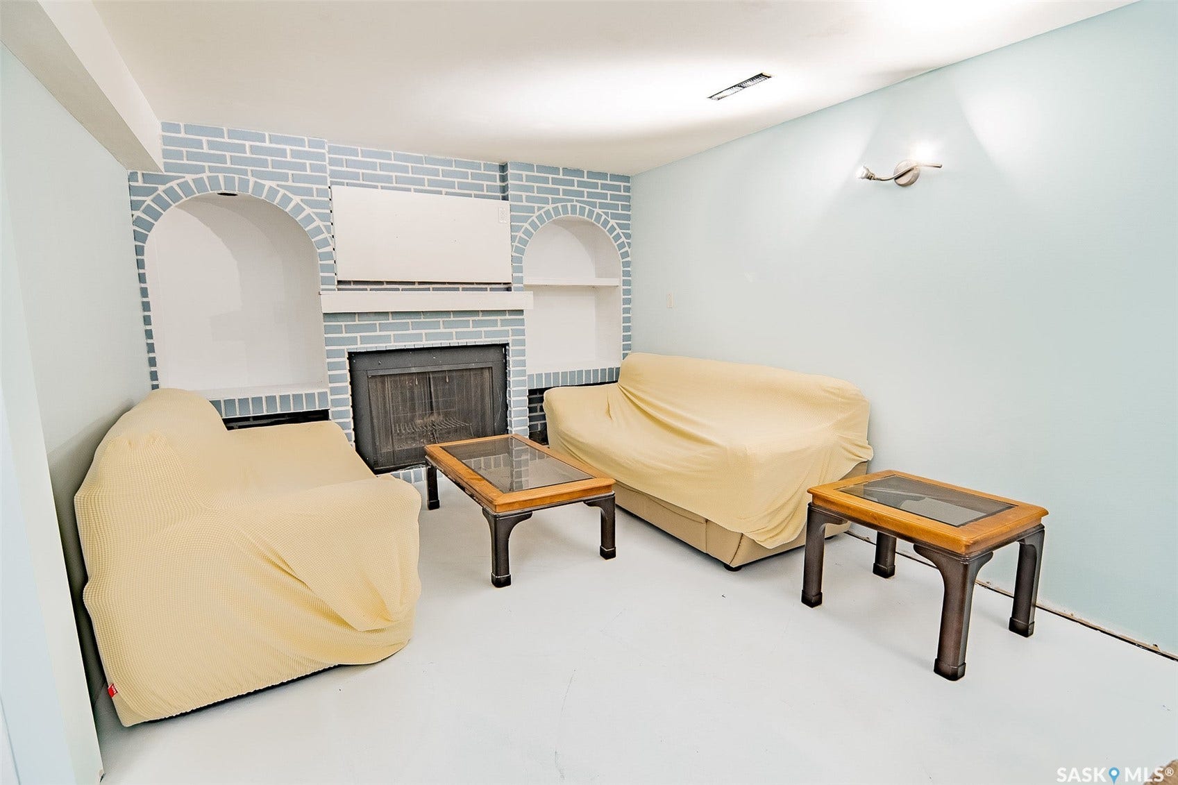 Brick fireplace with a dark metal firebox, flanked by two arched built-in alcoves