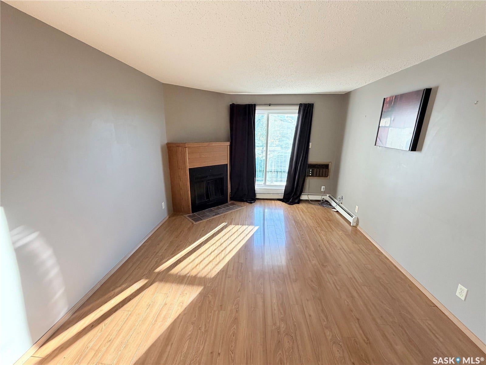 Wood-finish flooring throughout, featuring a fireplace with a wood surround and tile hearth