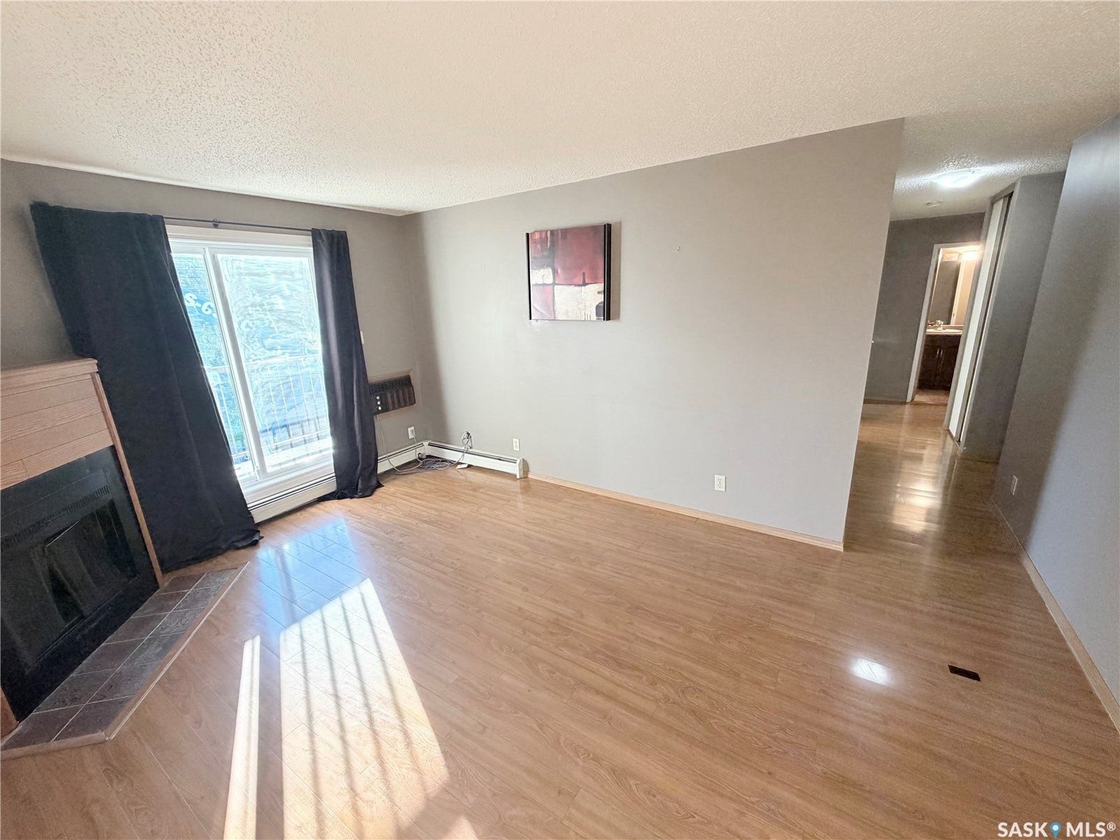 Wood-finish flooring throughout, featuring a fireplace with tile surround, and a large sliding glass door