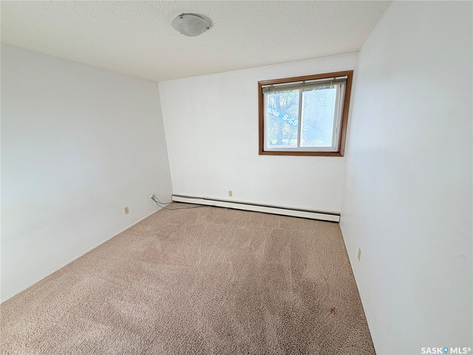 Textured ceiling with flush-mount lighting, neutral wall paint, and carpet flooring