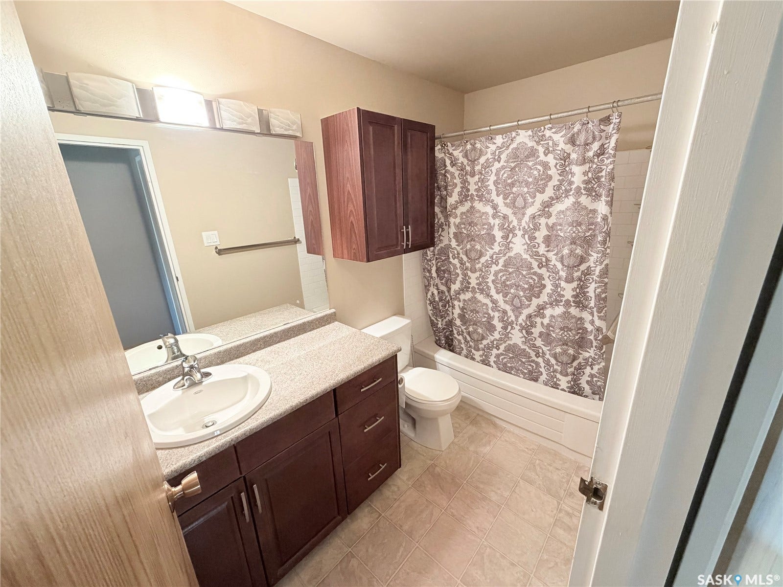 Bathroom featuring a built-in vanity with an integrated sink, substantial mirror, and overhead lighting
