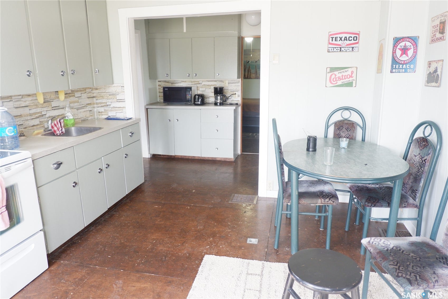 Kitchen featuring decorative backsplash, white range with electric cooktop, light countertops, and black microwave