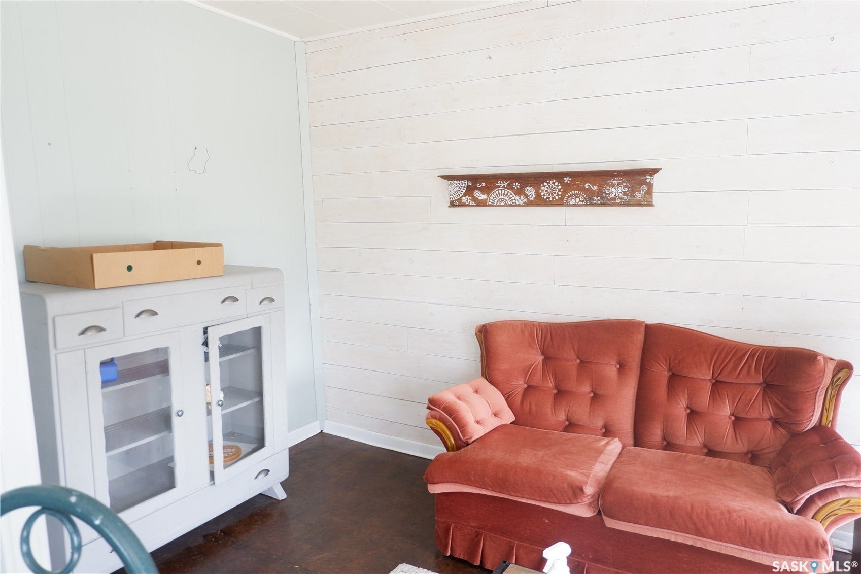 Sitting room featuring wooden walls, baseboards, and dark wood-style floors