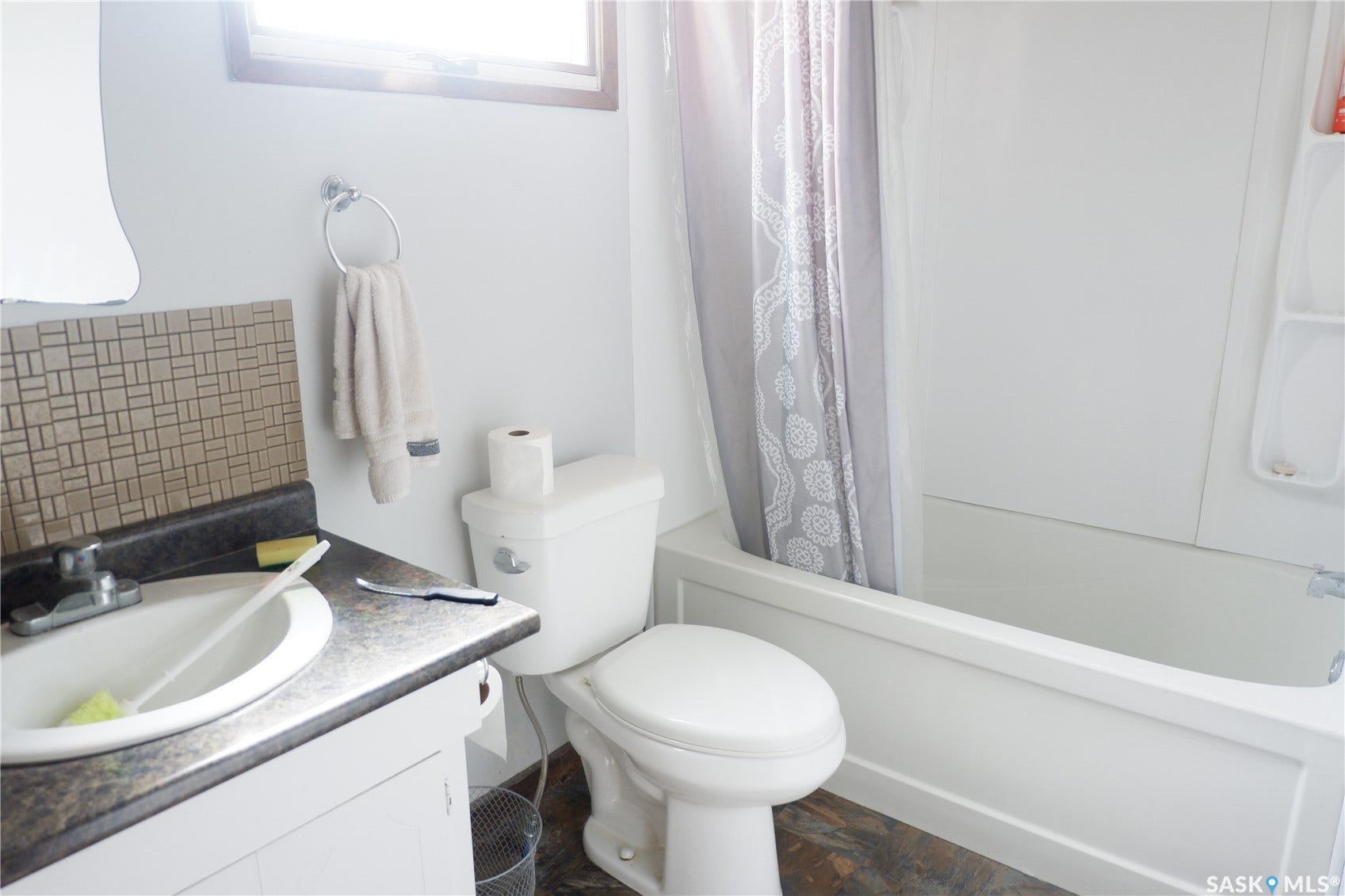 Bathroom featuring backsplash, toilet, shower / tub combo with curtain, and vanity