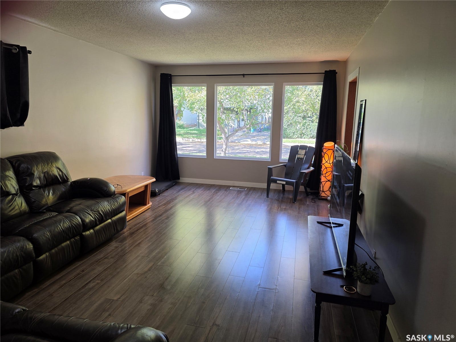 Wood-finish flooring, neutral wall paint, and multiple windows providing natural light