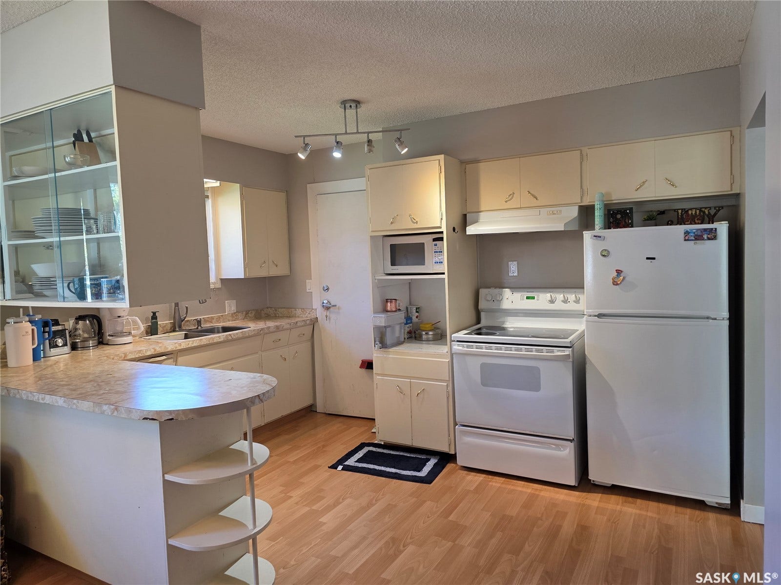 Kitchen featuring wood-finish flooring, white cabinetry, a built-in microwave, and a white electric range with a coordinating refrigerator