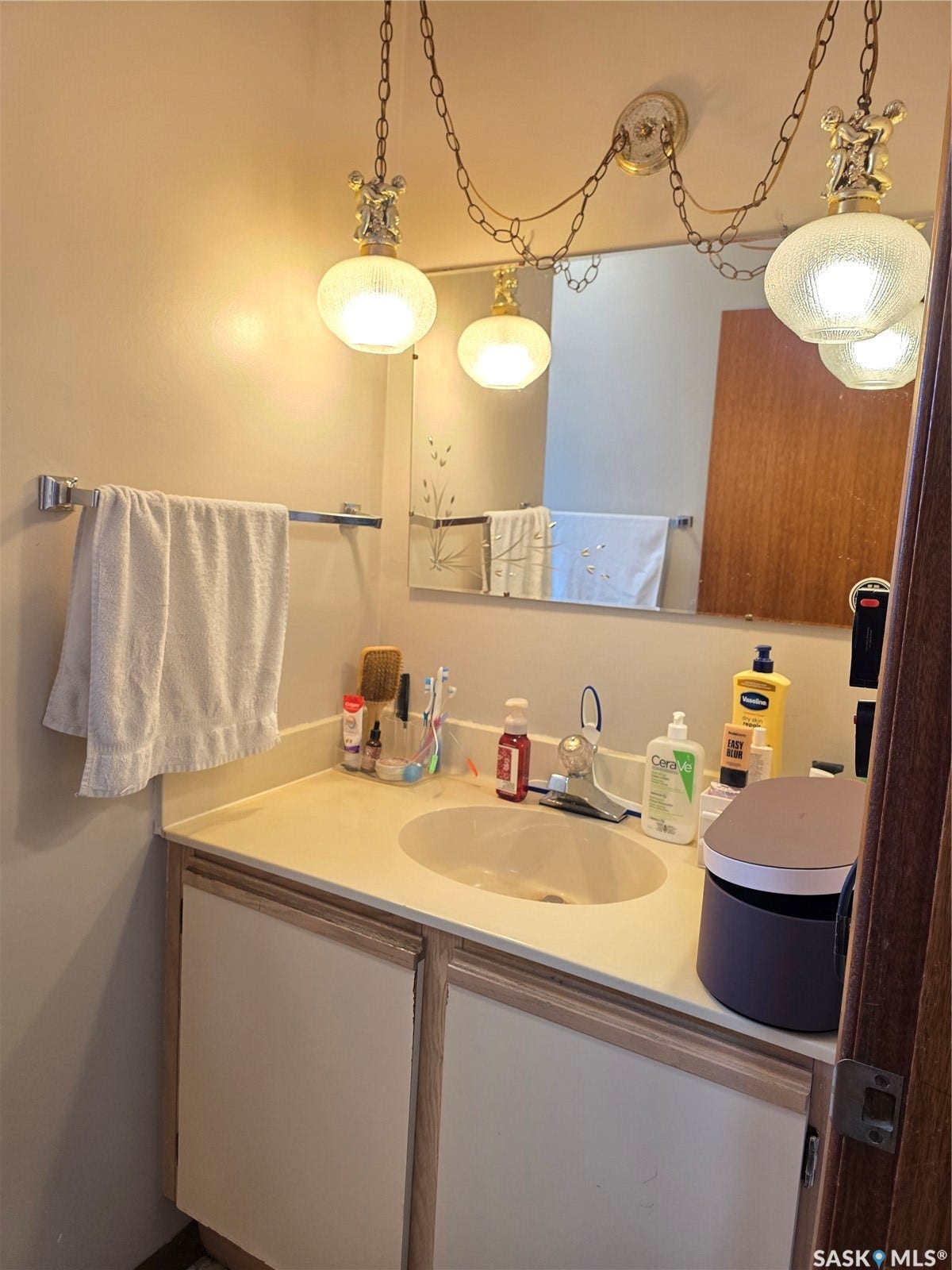 Vanity with integrated sink, dual-door cabinetry, and wall-mounted mirror