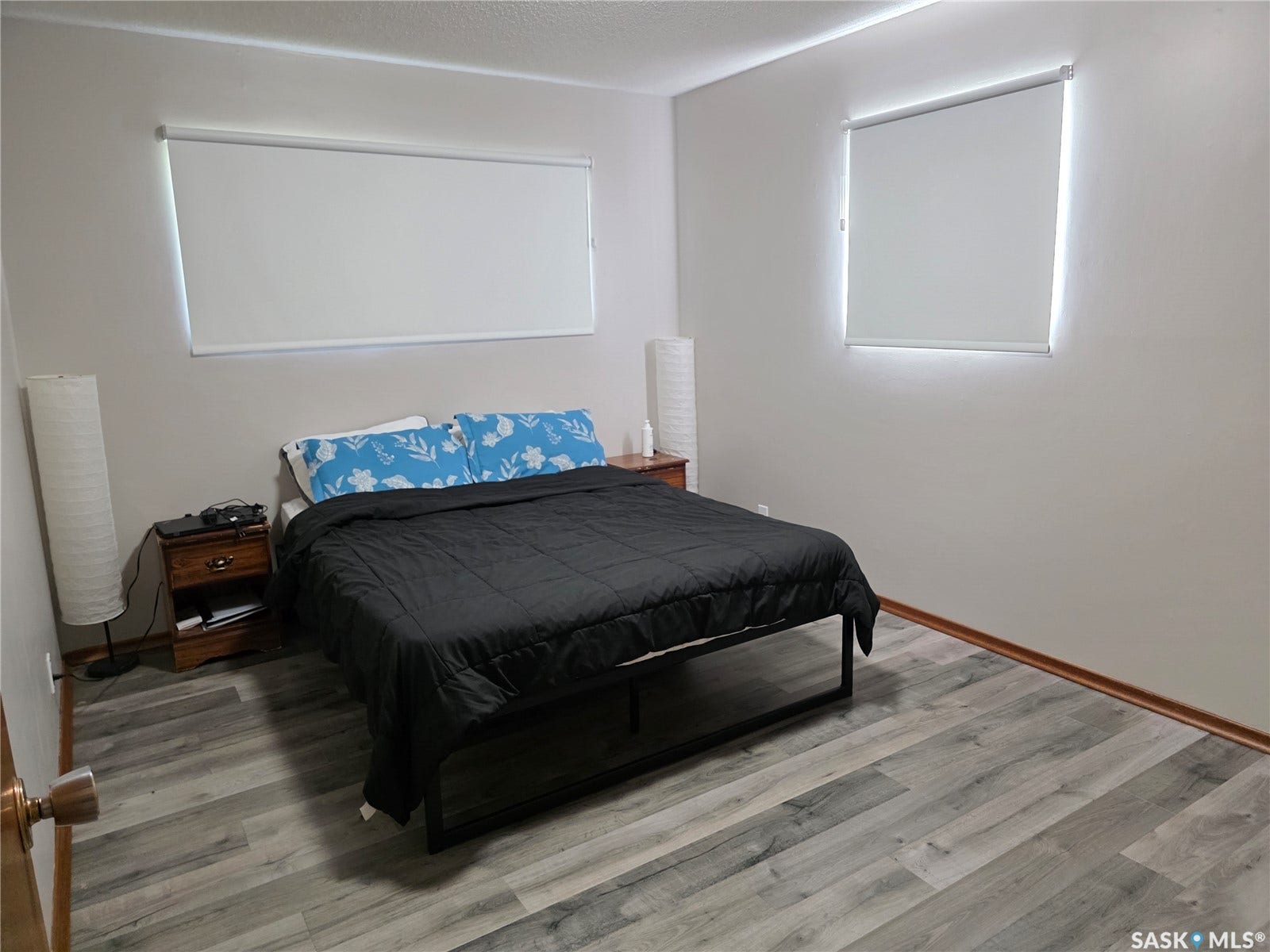 Neutral wall color, wood-finish flooring, and roller shades