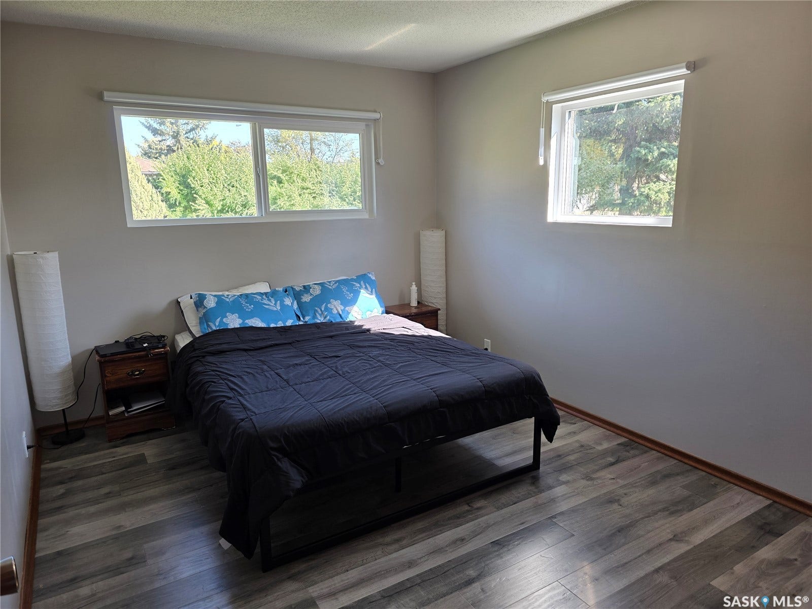 Light gray wall paint, wood-finish flooring, and multiple windows