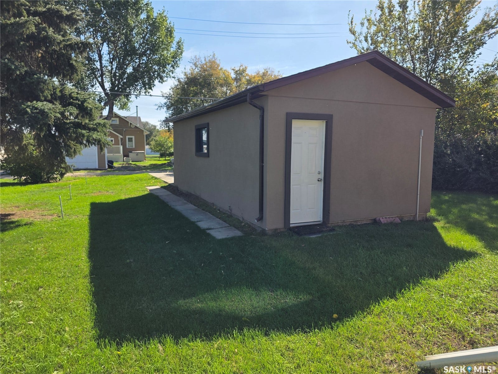 Detached structure with stucco exterior, single window, and a gabled roofline