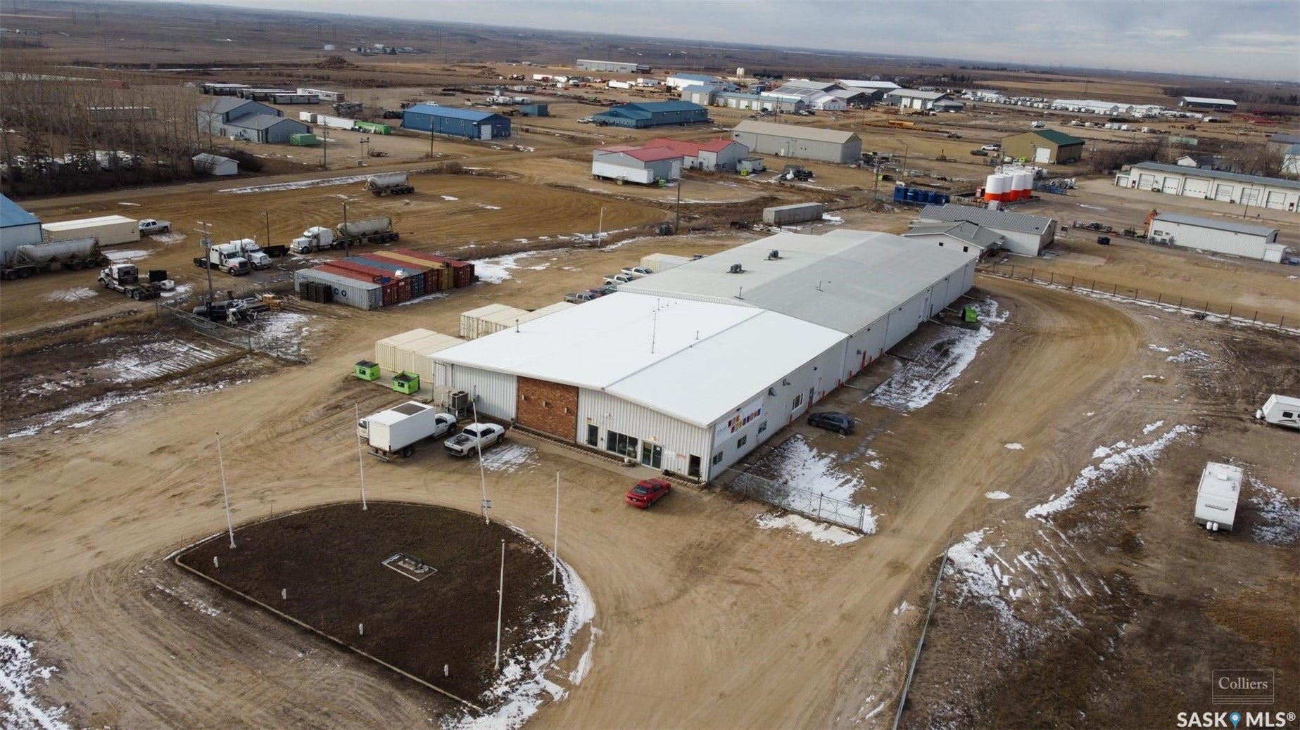Expansive industrial property featuring a large warehouse structure, multiple access points, and surrounding open land