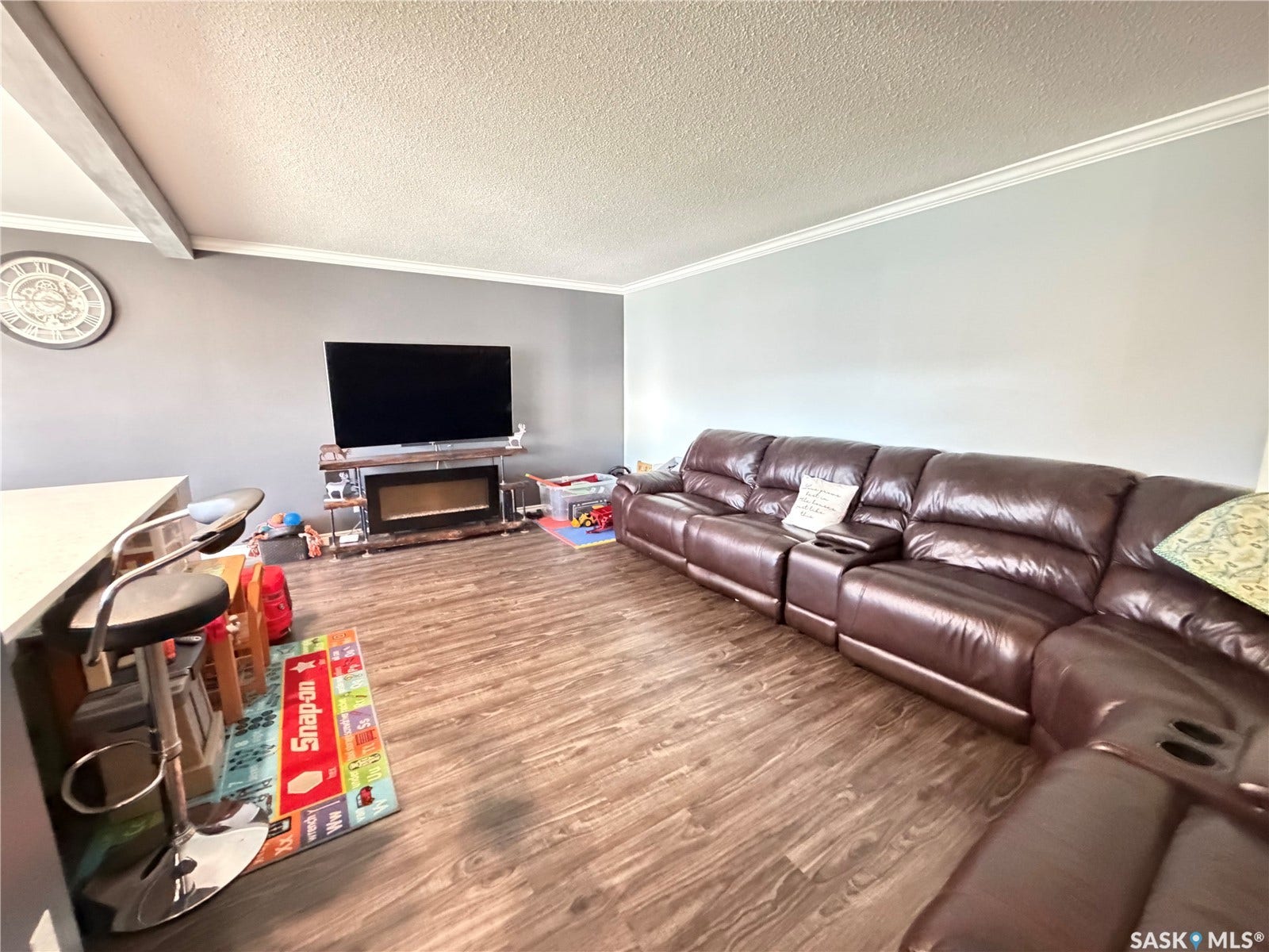 Wood-finish flooring throughout, complemented by crown molding and a built-in electric fireplace