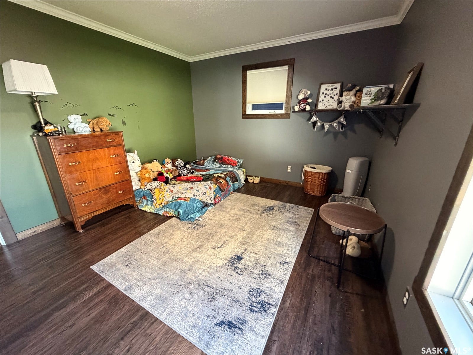 Dark wood-finish flooring, crown molding, and a built-in wall shelf