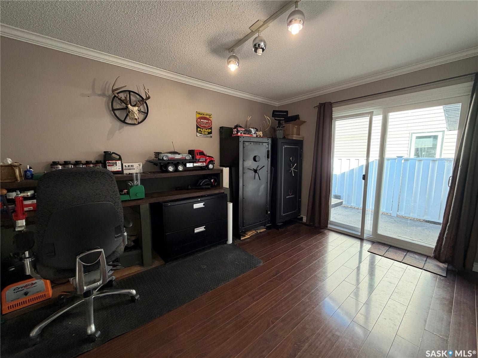 Wood-finish flooring, sliding glass door, crown molding, and track lighting