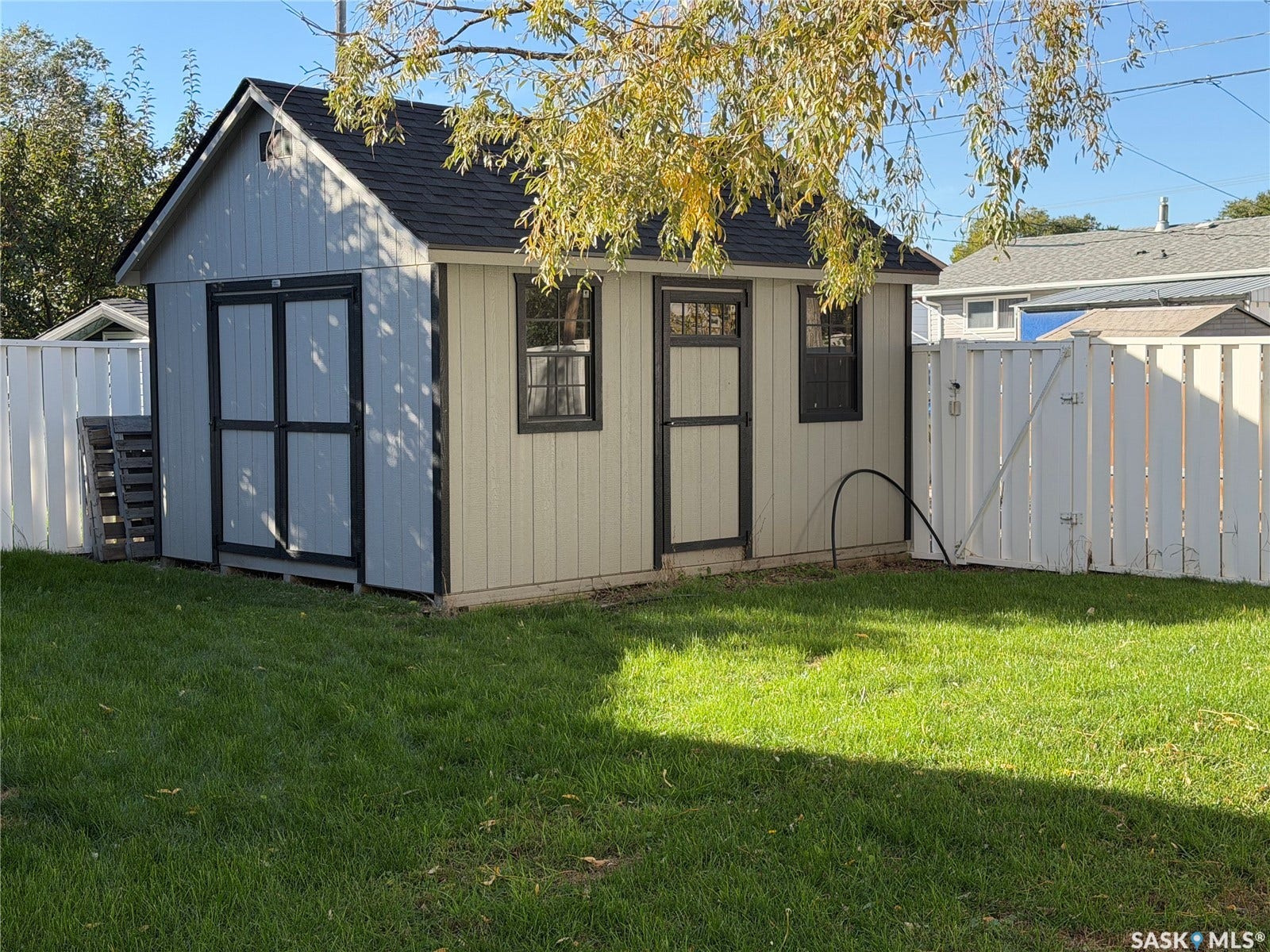 Gable roof shed featuring a side entry, double doors, and two windows