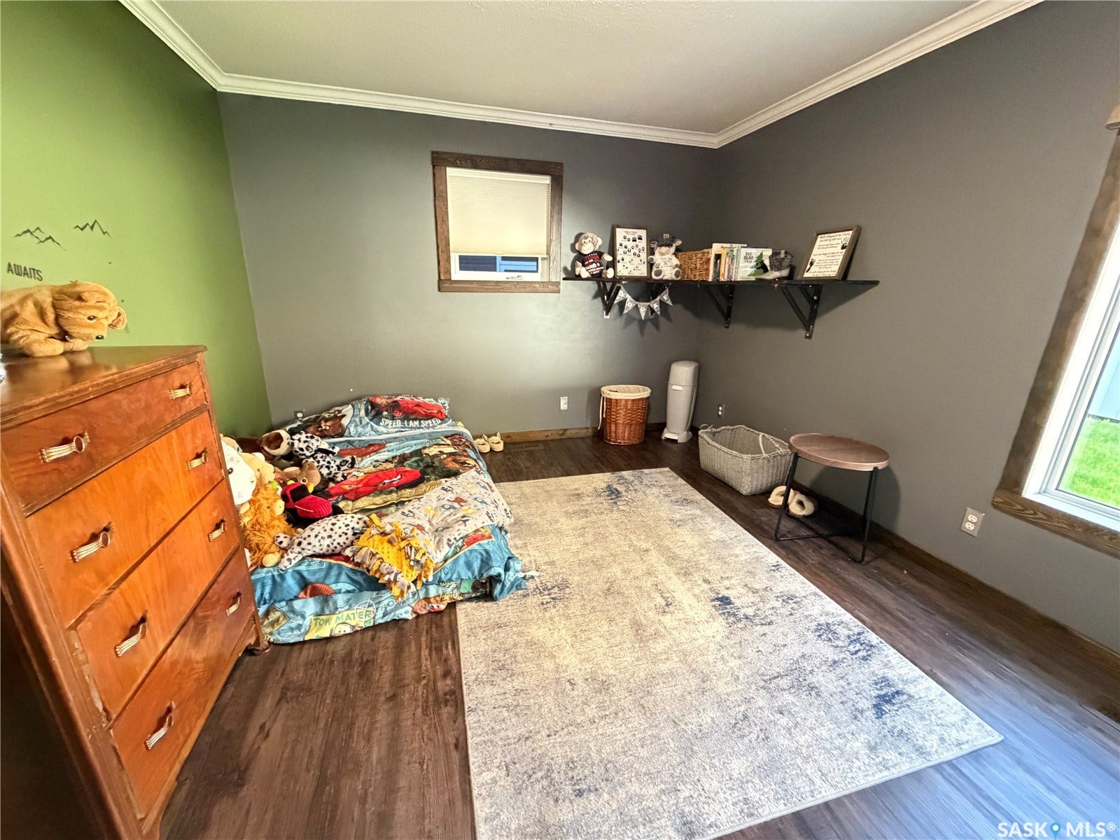 Dark wood-finish flooring, crown molding, and contrasting wall colors create a distinct aesthetic