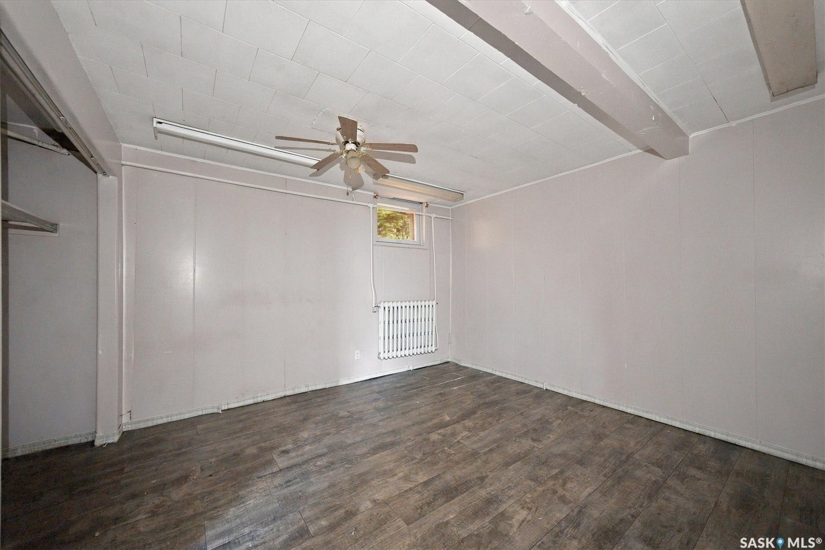 Wood-finish flooring, paneled walls, and a ceiling fan