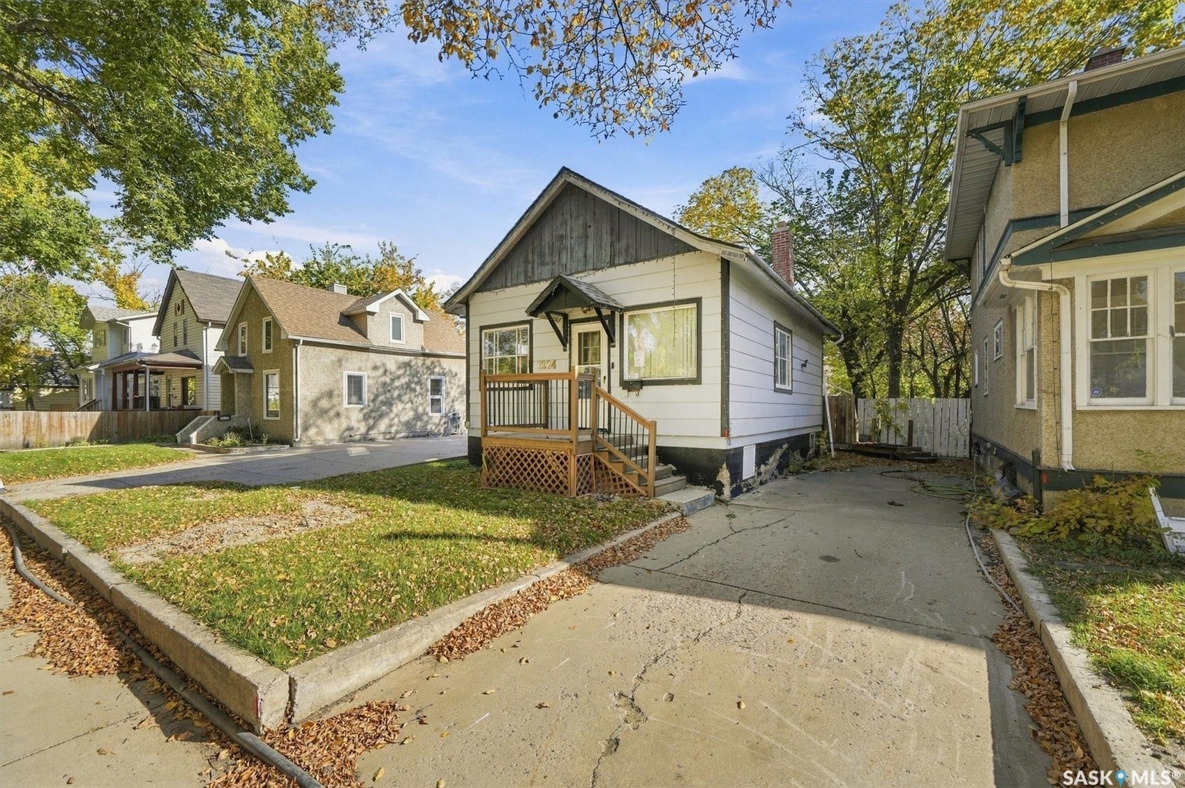 White siding exterior with dark trim and a wood deck