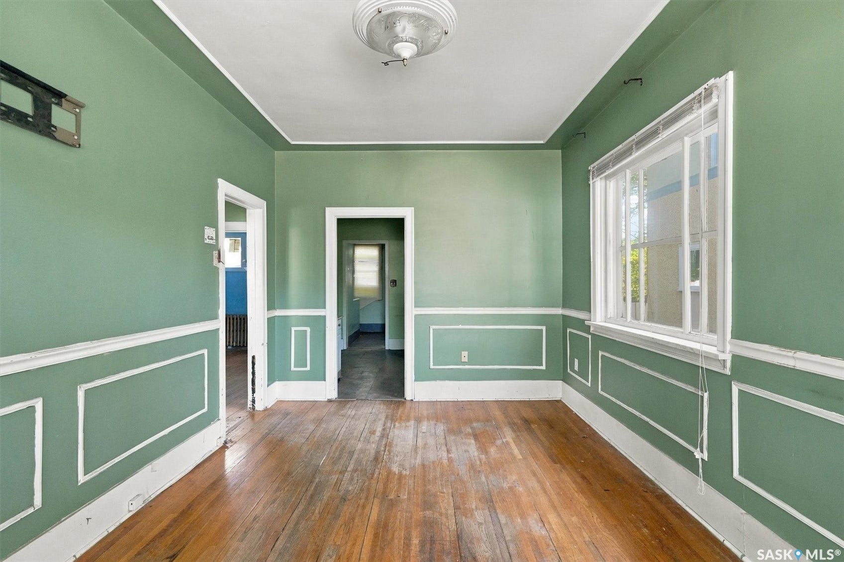 Hardwood flooring, picture frame molding, recessed ceiling, multiple doorways, and natural light from a window