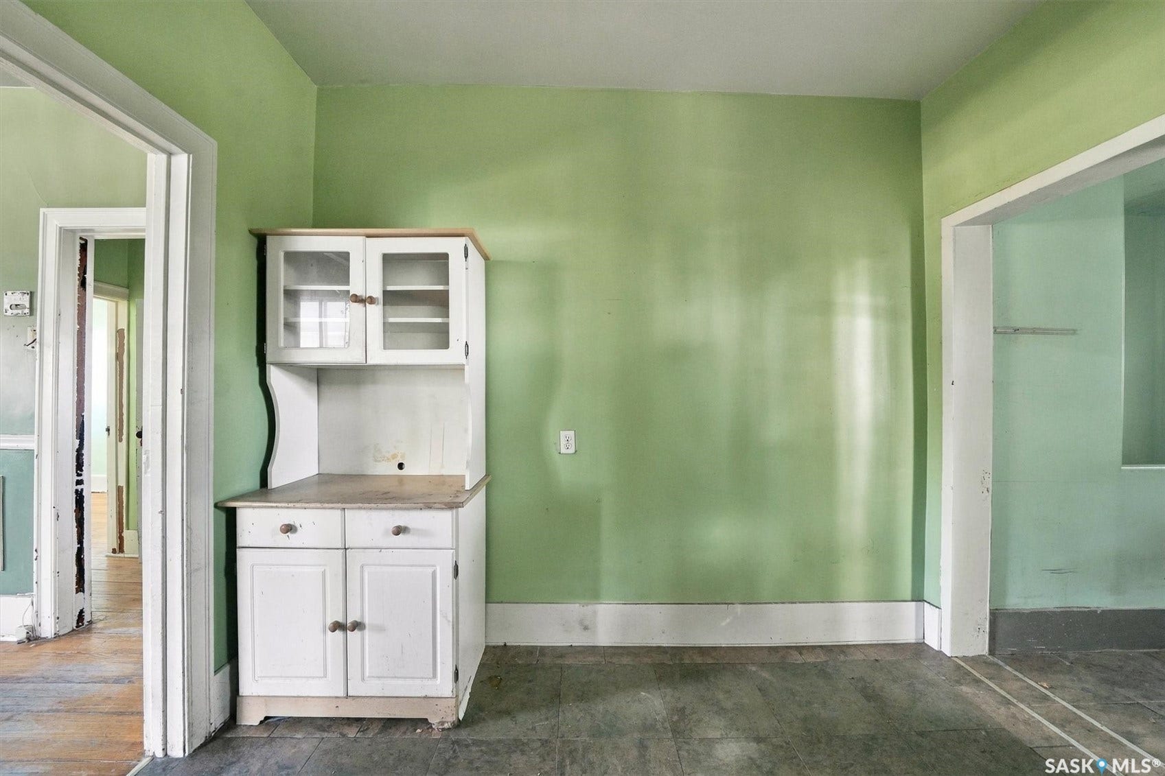 Built-in corner hutch with glass-front upper cabinetry and solid lower cabinetry, wood-finish countertop, and white baseboard trim
