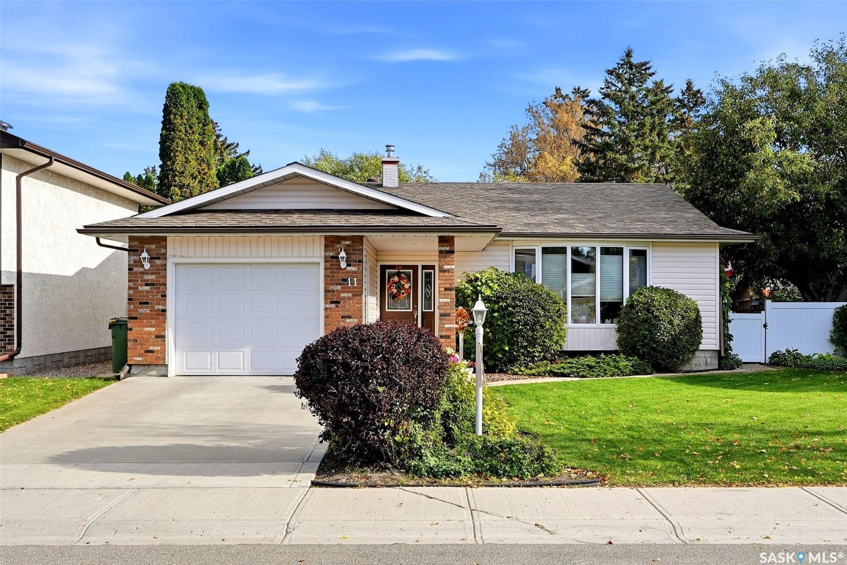 Single-story residence featuring a concrete driveway, attached garage, and brick detailing on the facade