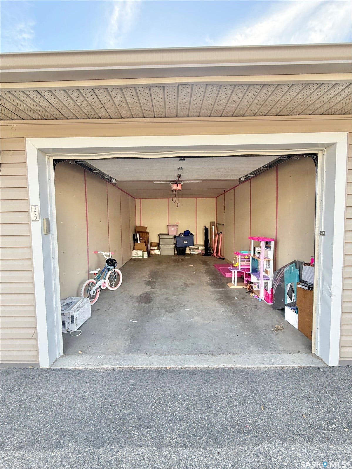 Single-car garage with concrete flooring, finished interior walls, and an overhead garage door