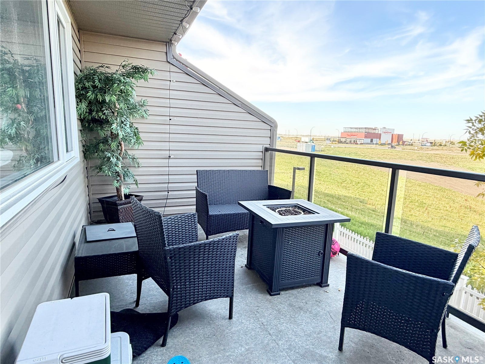 Concrete balcony featuring a glass and metal railing, and horizontal siding